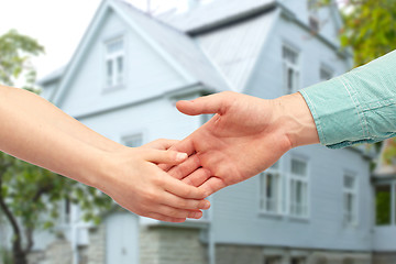 Image showing father and child holding hands over house