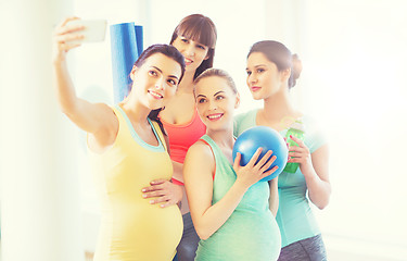 Image showing pregnant women taking selfie by smartphone in gym