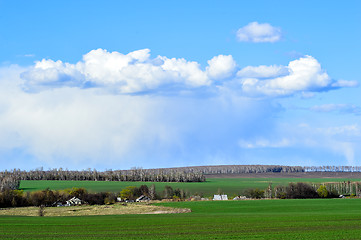 Image showing Rural landscape with a green field, clouds and farm