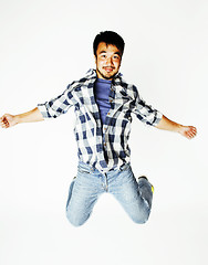 Image showing young pretty asian man jumping cheerful against white background