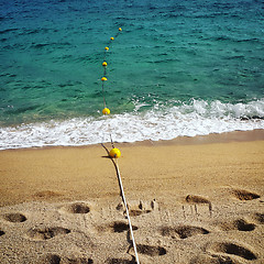 Image showing Rope with floats and footprints on the beach