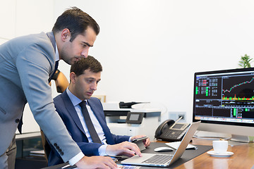 Image showing Business team remotely solving a problem at business meeting using laptop computer and touchpad.