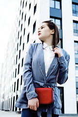 Image showing young pretty brunette business woman posing against modern building, lifestyle people concept