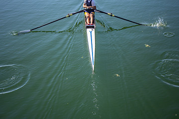 Image showing A young girl rowing in boat on water