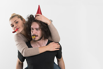 Image showing couple in party hats blowing in whistle