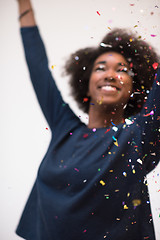 Image showing African American woman blowing confetti in the air