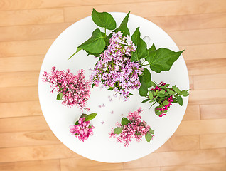 Image showing Spring flowers on a white round table