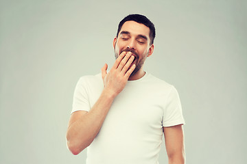 Image showing yawning man over gray background