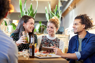 Image showing friends with tablet pc, drinks and food at bar