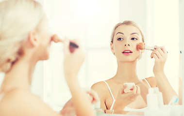 Image showing woman with makeup brush and powder at bathroom