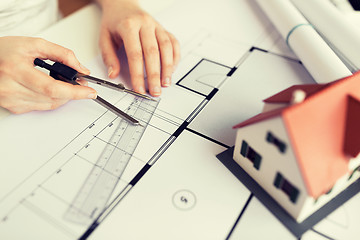 Image showing close up of hands with compass measuring blueprint