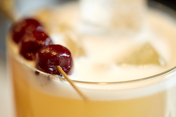 Image showing close up of cocktail glass with cherries at bar