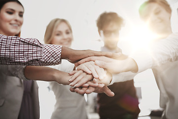 Image showing happy business team with hands on top at office