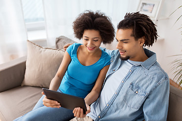 Image showing smiling happy couple with tablet pc at home