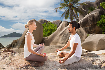 Image showing happy couple doing yoga and meditating outdoors