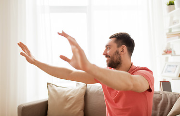 Image showing happy man touching something imaginary at home