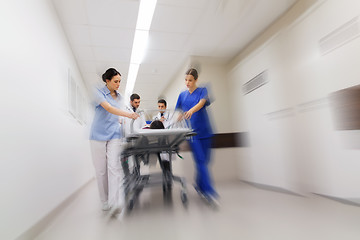 Image showing medics and patient on hospital gurney at emergency