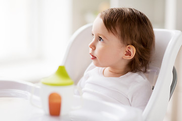 Image showing happy baby girl sitting in highchair at home