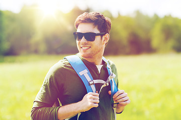 Image showing happy young man with backpack hiking outdoors