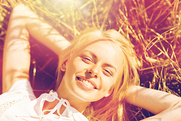 Image showing happy young woman lying on cereal field