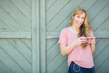 Image showing Outdoor Portrait of Young Adult Brown Eyed Woman Listening To Mu