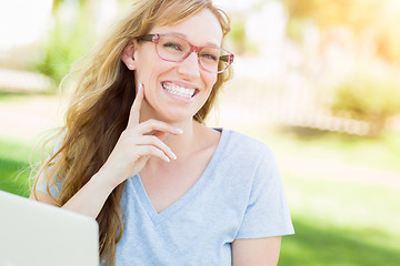 Image showing Young Adult Woman Wearing Glasses Outdoors Using Her Laptop.