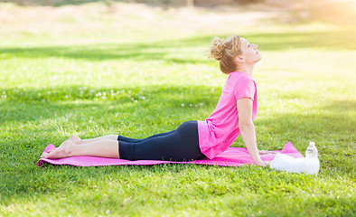 Image showing Young Fit Adult Woman Outdoors on The Grass Doing the Upward Dog