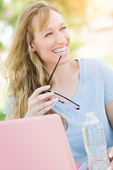 Image showing Young Adult Woman With Glasses Outdoors Using Her Laptop.