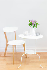 Image showing Elegant interior with table, chair and bouquet of lilacs