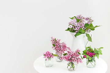 Image showing Vases with blooming spring flowers on a round table