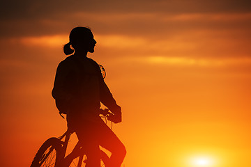 Image showing Silhouette of a bike on sky background during sunset