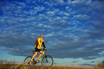 Image showing Young man cycling on a rural road