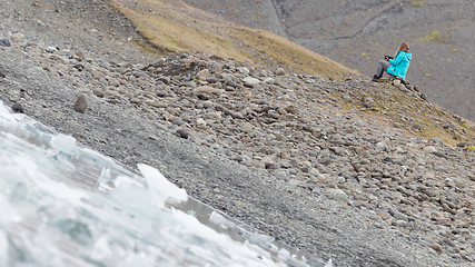 Image showing Woman sitting on the beach at Jokulsarlon glacier lagoon - Icela