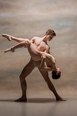 Image showing Couple of ballet dancers posing over gray background