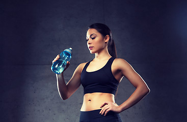Image showing woman drinking water from bottle in gym