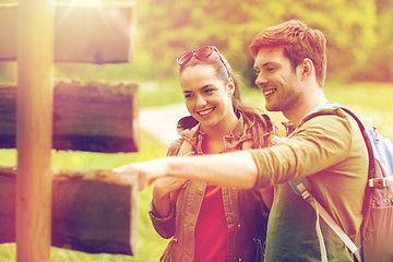 Image showing smiling couple at signpost with backpacks hiking