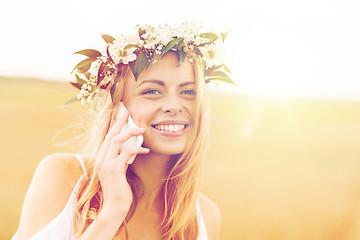 Image showing happy young woman calling on smartphone at country