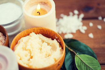 Image showing close up of natural body scrub and candle on wood