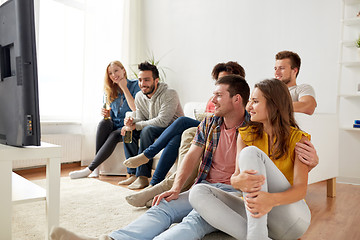 Image showing happy friends with popcorn watching tv at home