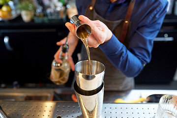 Image showing bartender with shaker preparing cocktail at bar