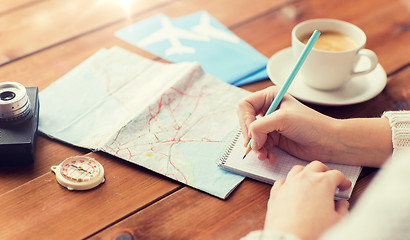 Image showing close up of traveler hands with notepad and pencil