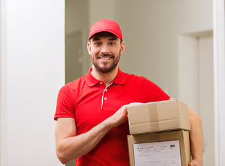 Image showing delivery man with parcel boxes in corridor