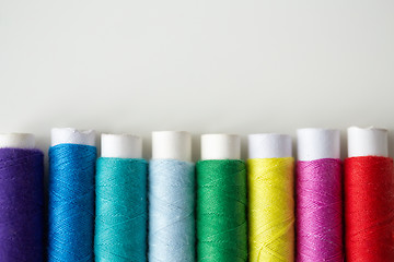 Image showing row of colorful thread spools on table