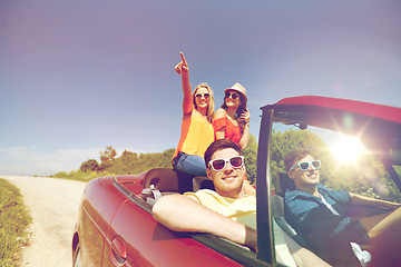 Image showing happy friends driving in cabriolet car at country