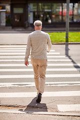 Image showing senior man walking along city crosswalk