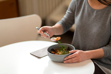 Image showing woman eating fish soup at cafe or restaurant
