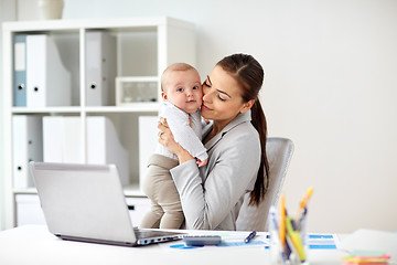 Image showing happy businesswoman with baby and laptop at office