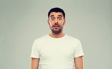 Image showing scared man in white t-shirt over gray background