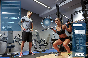 Image showing man and woman with bar flexing muscles in gym