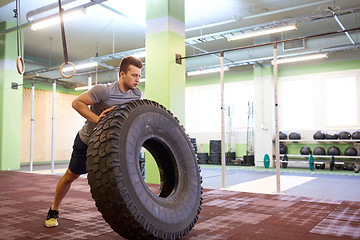 Image showing man doing strongman tire flip training in gym